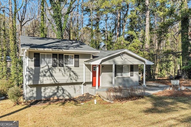 tri-level home with covered porch and a front lawn