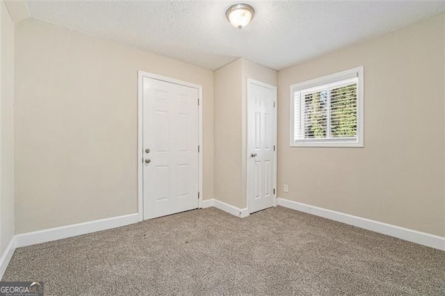 empty room featuring a textured ceiling and carpet floors