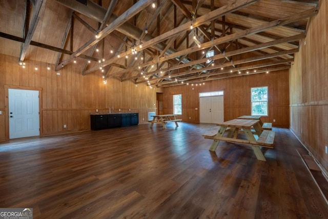 miscellaneous room with wood walls, wood finished floors, and beamed ceiling