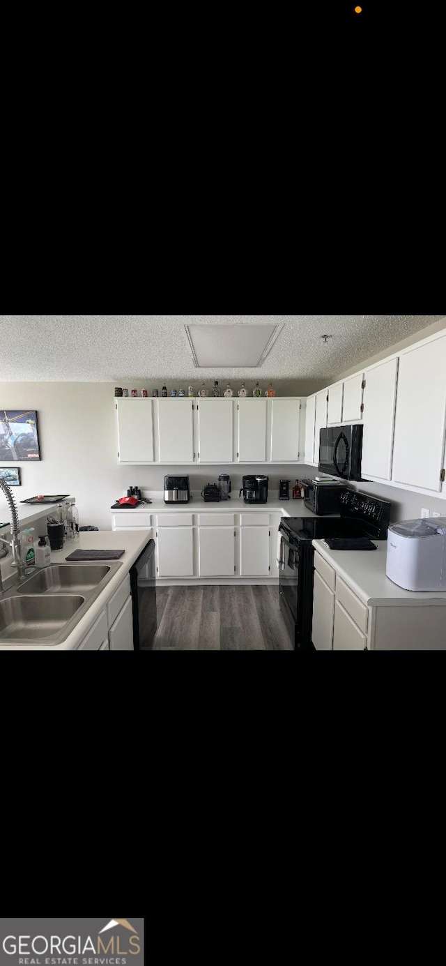 kitchen with sink, white cabinetry, a textured ceiling, dark hardwood / wood-style flooring, and black appliances