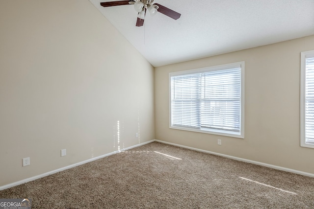 carpeted spare room with a healthy amount of sunlight, ceiling fan, and lofted ceiling