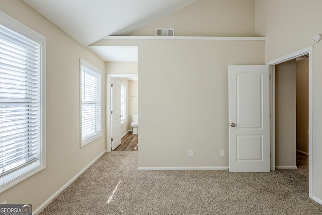 spare room featuring lofted ceiling and carpet