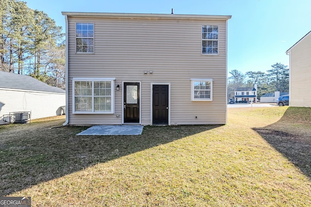 back of house featuring central air condition unit, a patio area, and a yard