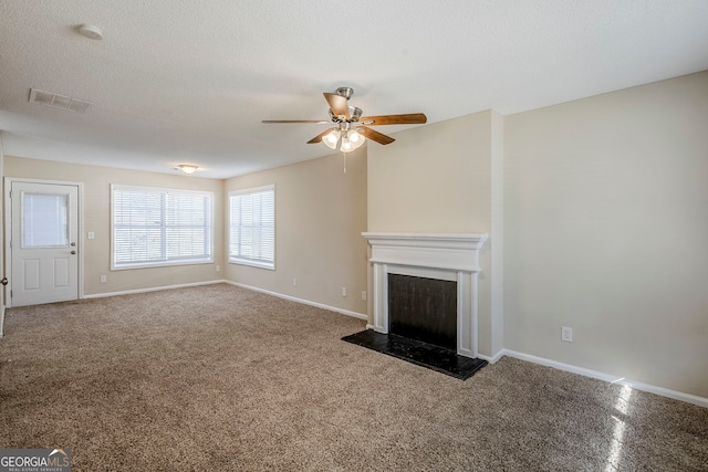 unfurnished living room with ceiling fan and a textured ceiling