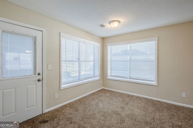 interior space featuring a textured ceiling and carpet