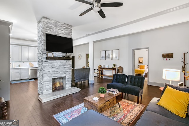 living room with ceiling fan, dark hardwood / wood-style floors, and a fireplace