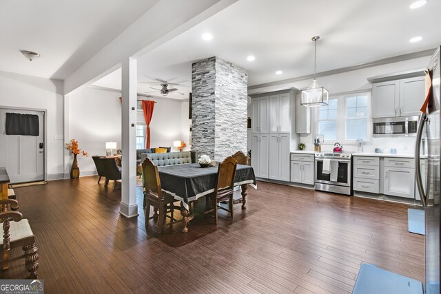 dining area featuring ornate columns, ceiling fan, and dark hardwood / wood-style floors