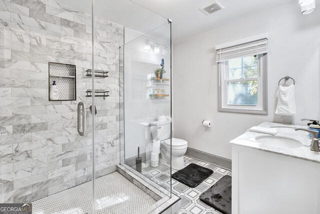 bathroom featuring toilet, an enclosed shower, vanity, and tile patterned flooring