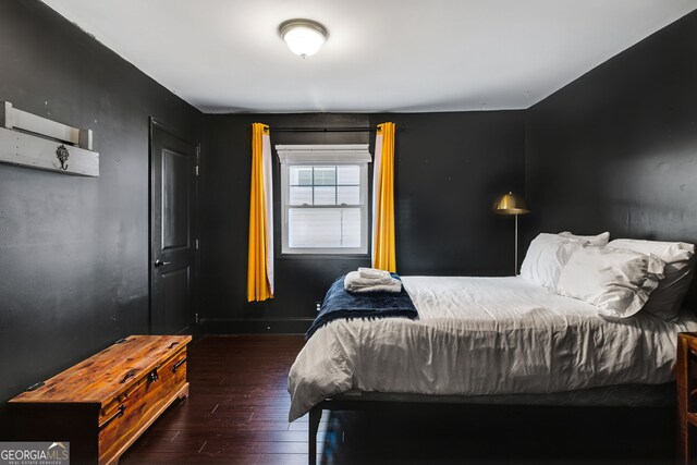 bedroom with dark hardwood / wood-style flooring