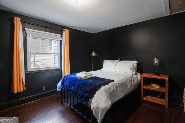 bedroom with dark hardwood / wood-style flooring