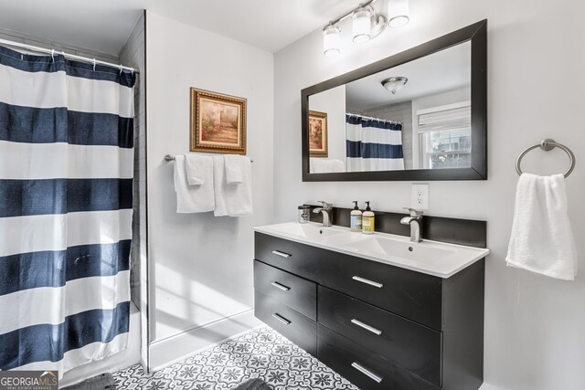 bathroom featuring tile patterned flooring, walk in shower, and vanity