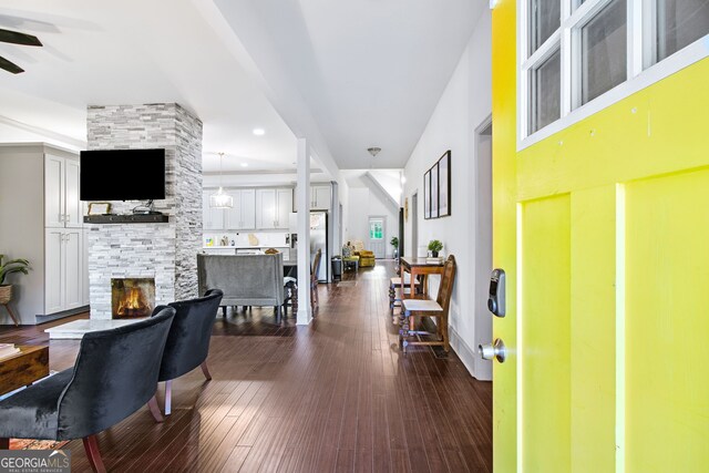 entryway featuring dark hardwood / wood-style flooring and a stone fireplace