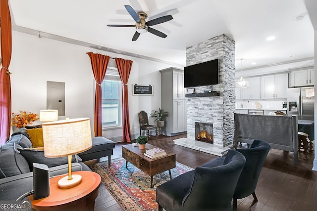 living room featuring a fireplace, ornamental molding, ceiling fan, and dark hardwood / wood-style floors