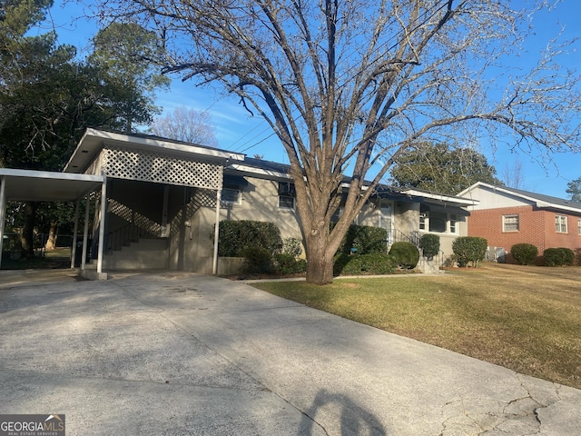 view of front of home with a front yard and a carport