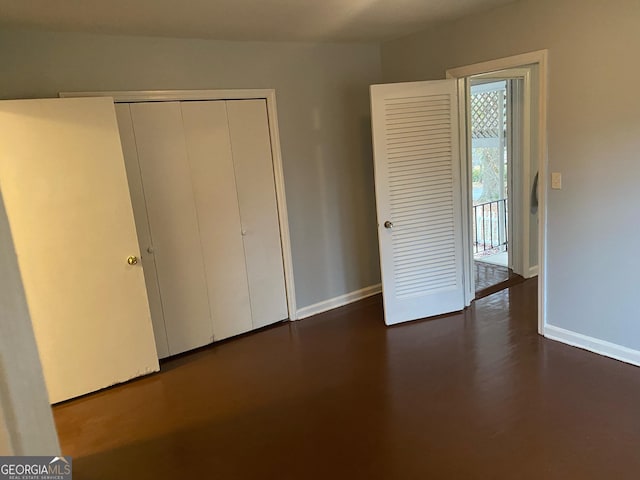 unfurnished bedroom featuring a closet and dark hardwood / wood-style flooring