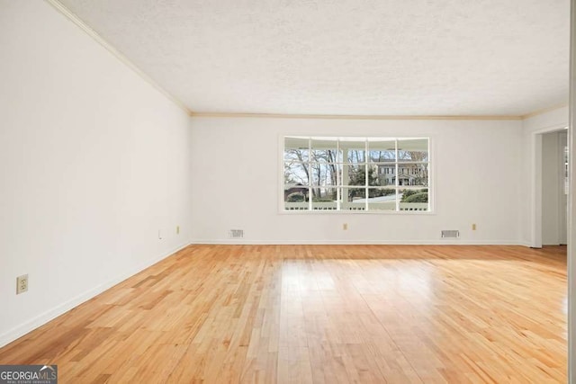 unfurnished room featuring a textured ceiling, crown molding, and light hardwood / wood-style flooring