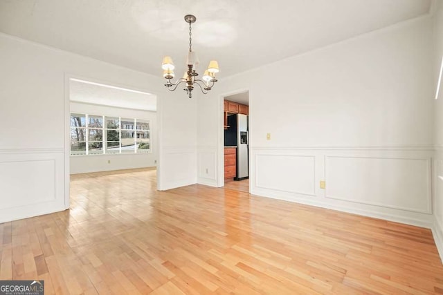 unfurnished dining area with light wood-type flooring and a chandelier