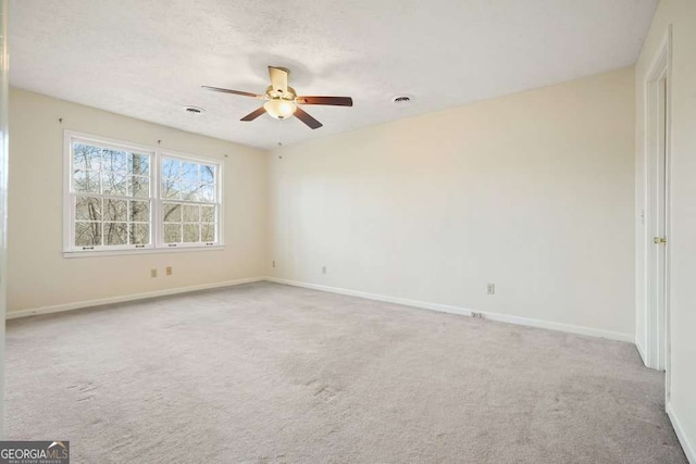 carpeted spare room featuring a textured ceiling and ceiling fan