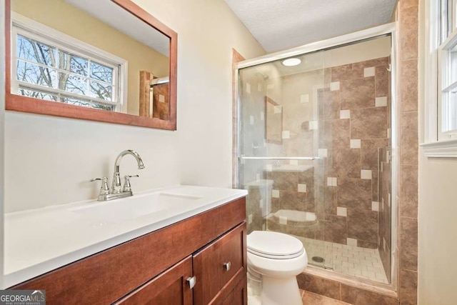 bathroom with toilet, a shower with door, and vanity