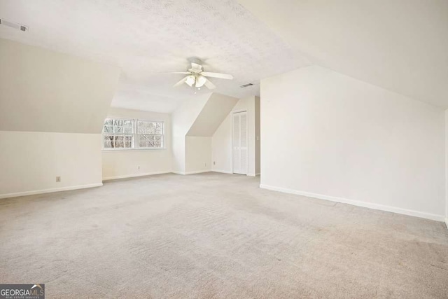 bonus room with light carpet, ceiling fan, and vaulted ceiling