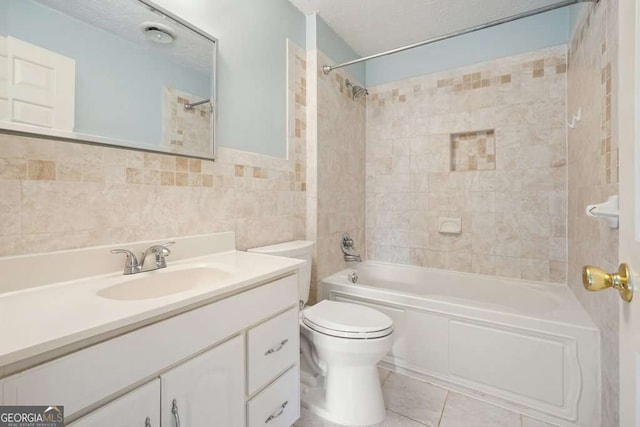 full bathroom with vanity, tile patterned floors, tile walls, tiled shower / bath, and a textured ceiling