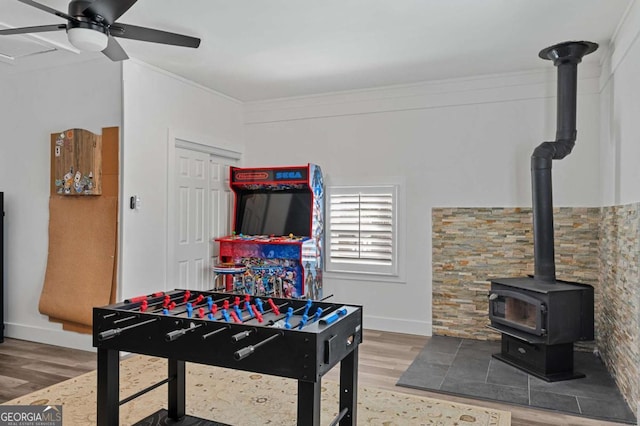 playroom featuring hardwood / wood-style flooring, ornamental molding, and ceiling fan