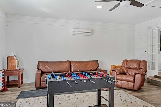 recreation room with ceiling fan, hardwood / wood-style floors, crown molding, and a wall mounted air conditioner