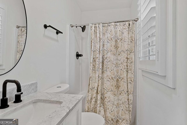 bathroom featuring toilet, walk in shower, and vanity