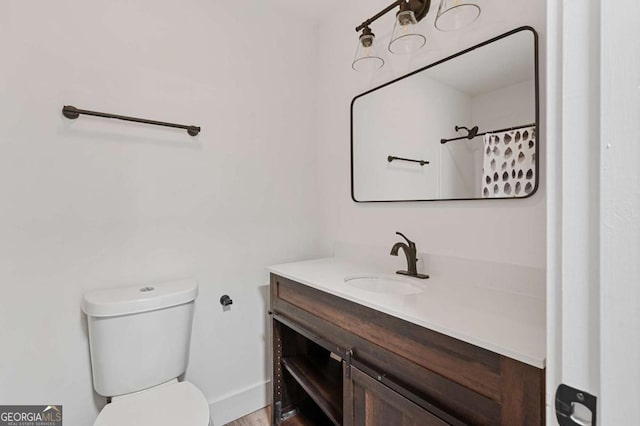 bathroom with toilet, vanity, and a shower with shower curtain