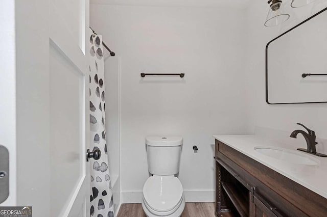 bathroom featuring toilet, hardwood / wood-style floors, and vanity