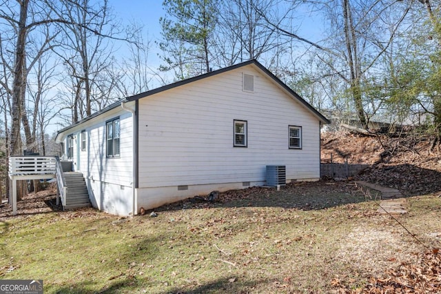 view of side of home featuring central AC and a yard