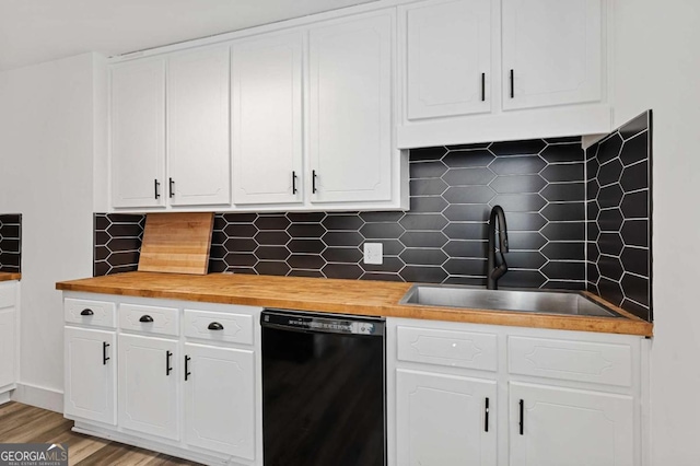 kitchen featuring tasteful backsplash, wood counters, black dishwasher, and white cabinetry