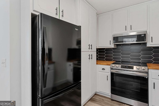 kitchen with stainless steel appliances, white cabinetry, and tasteful backsplash