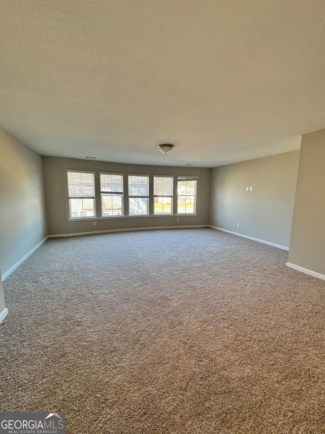 unfurnished room featuring a textured ceiling and carpet floors