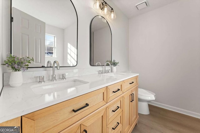 bathroom featuring hardwood / wood-style floors, vanity, and toilet