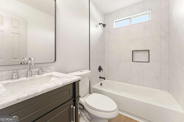 full bathroom with toilet, vanity, and tiled shower / bath