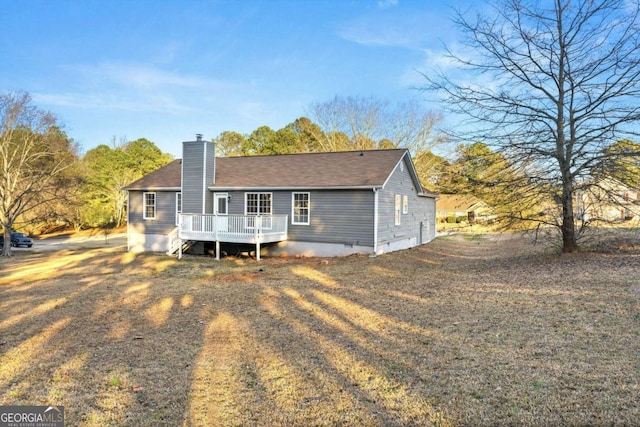 rear view of property featuring a wooden deck