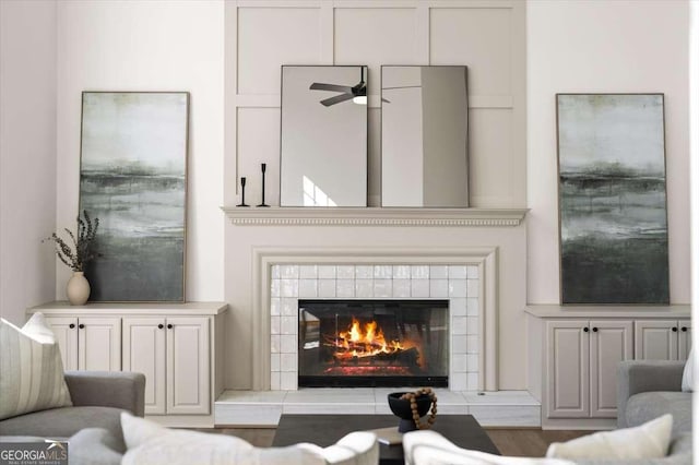 living room with ceiling fan and a fireplace