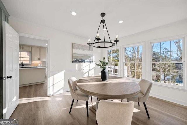 dining area with hardwood / wood-style flooring, a wealth of natural light, and a chandelier