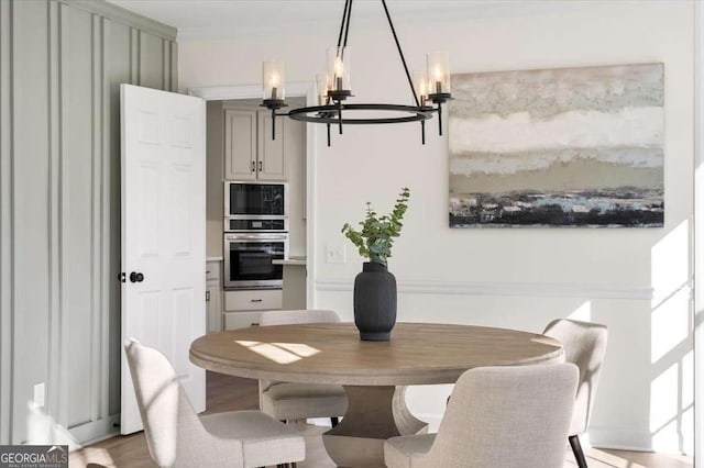 dining room with light wood-type flooring and a chandelier