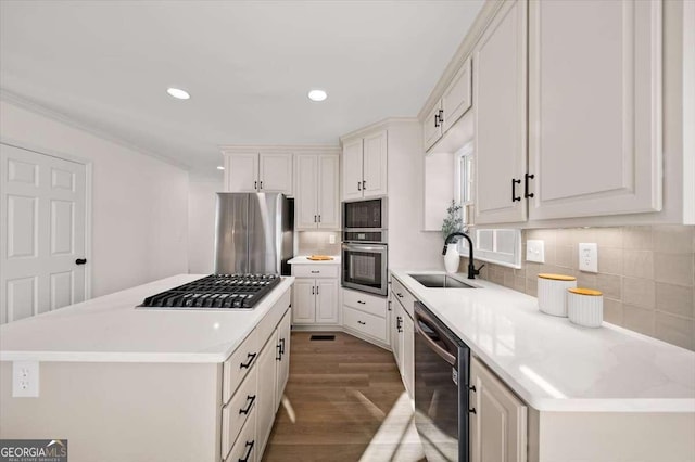 kitchen featuring sink, white cabinets, backsplash, and appliances with stainless steel finishes