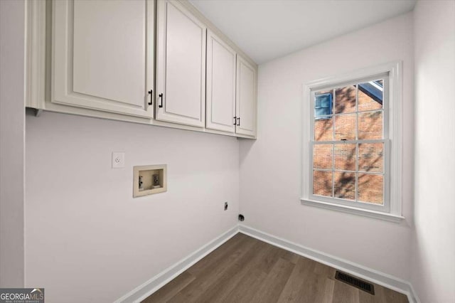 laundry area featuring electric dryer hookup, washer hookup, cabinets, and dark wood-type flooring