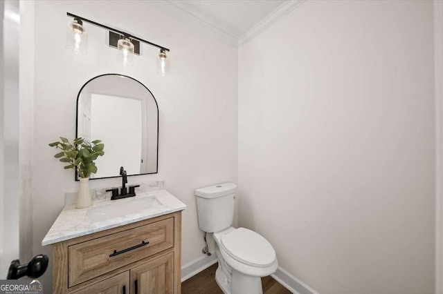 bathroom with ornamental molding, vanity, and toilet