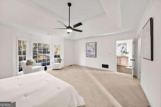 bedroom with a raised ceiling, ceiling fan, and light carpet