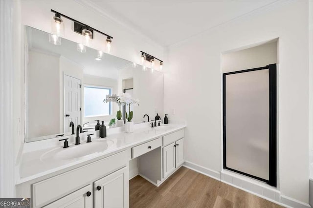 bathroom with vanity, ornamental molding, hardwood / wood-style flooring, and walk in shower