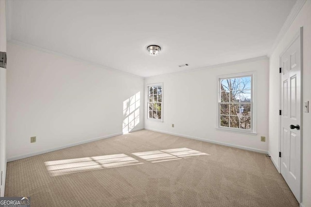 carpeted empty room featuring crown molding and plenty of natural light