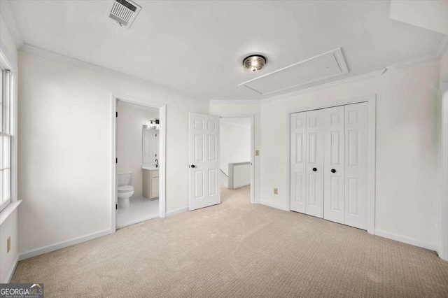 unfurnished bedroom with a closet, connected bathroom, ornamental molding, and light colored carpet