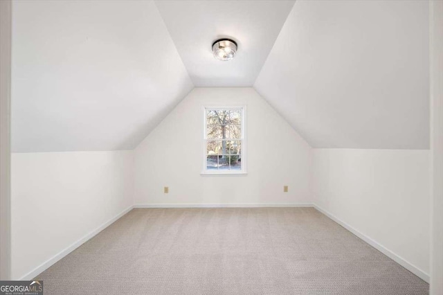 bonus room featuring lofted ceiling and light carpet