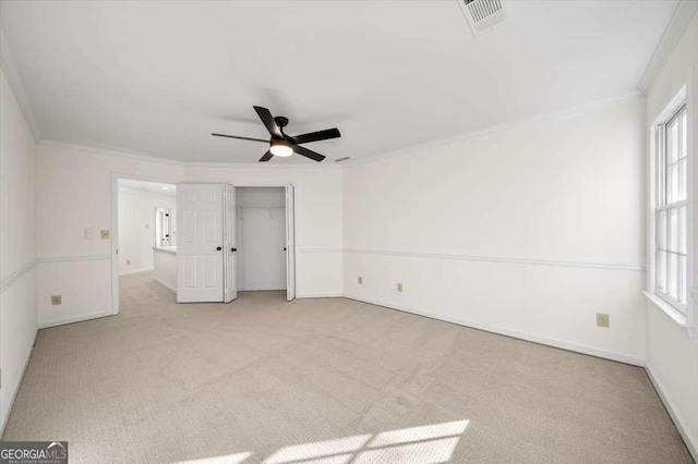 unfurnished bedroom with light carpet, a closet, ceiling fan, and crown molding