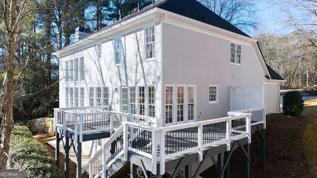 rear view of property featuring a wooden deck